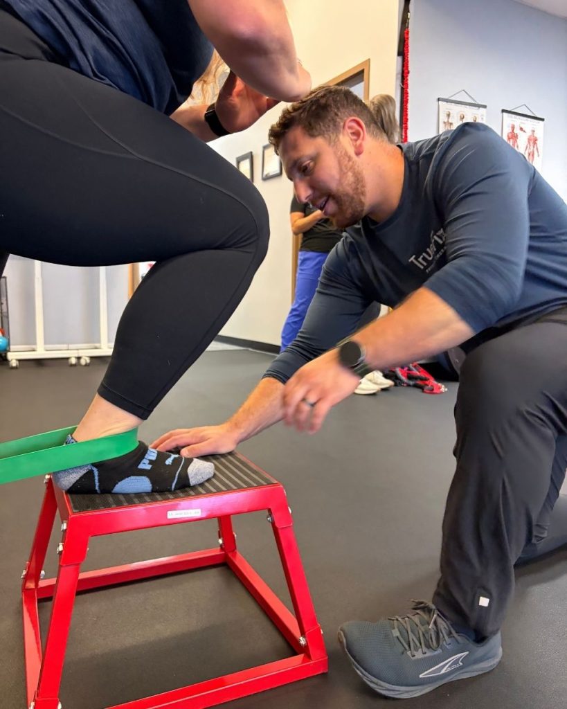 Physical therapist teaching an ankle exercise at TrueFix Physical Therapy in Shawnee, KS