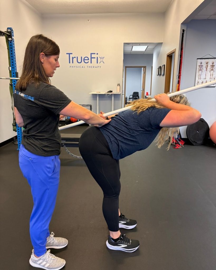 Physical therapist teaches a lower back exercise at TrueFix Physical Therapy in Shawnee, KS