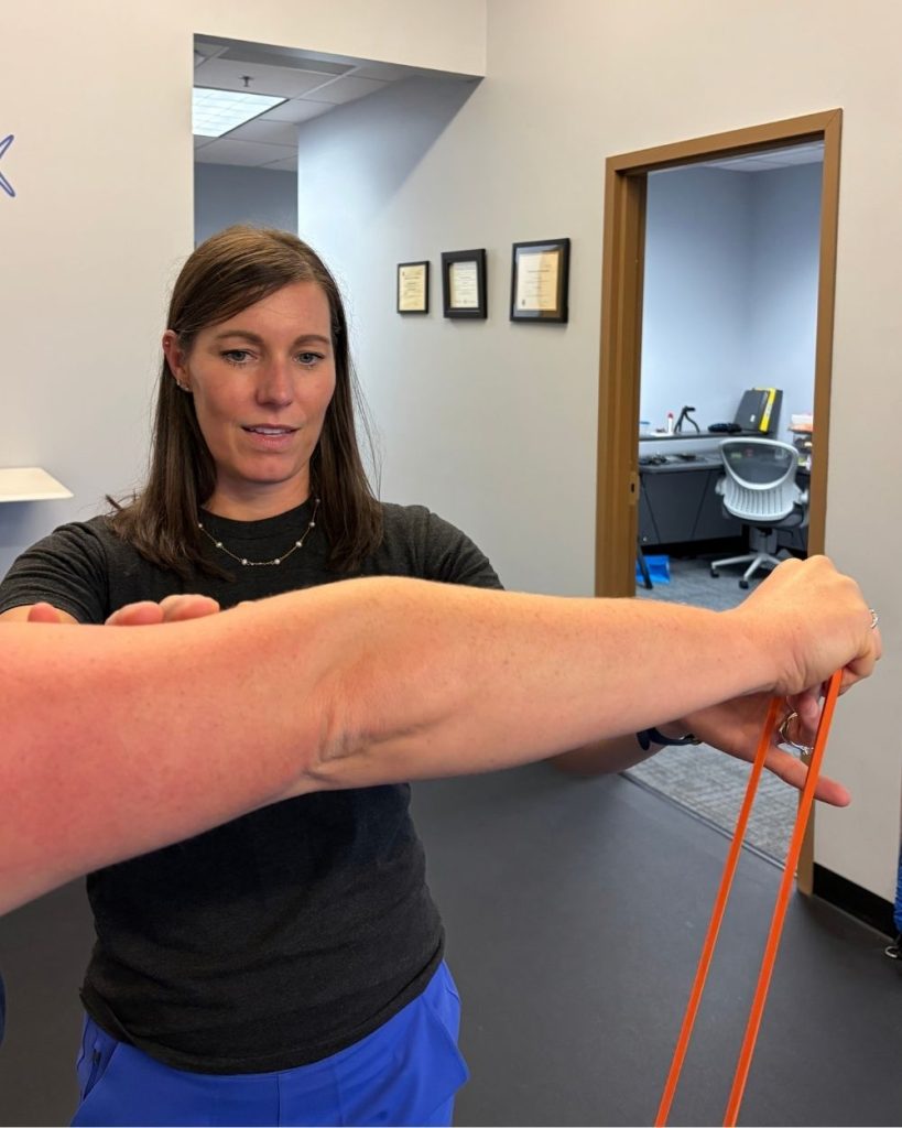 Physical therapist teaches an elbow exercise at TrueFix Physical Therapy in Shawnee, KS