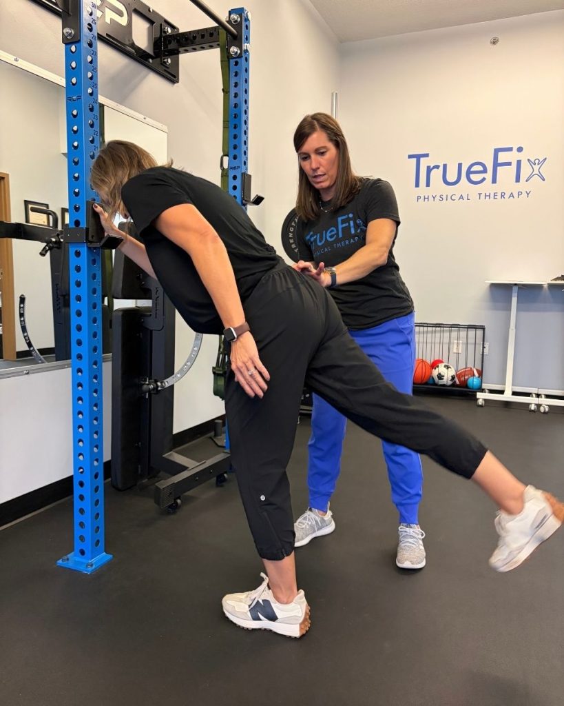 Physical therapist teaches a hip exercise at TrueFix Physical Therapy in Shawnee, KS