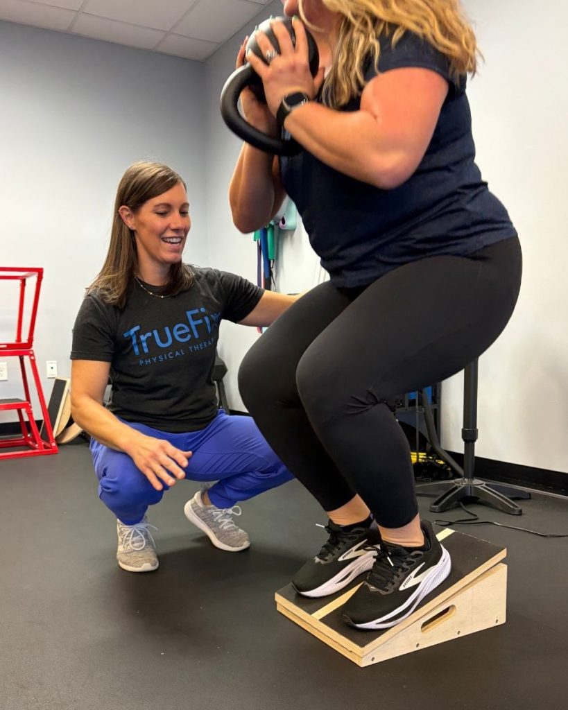 Physical therapist teaches knee exercise at TrueFix Physical Therapy in Shawnee, KS