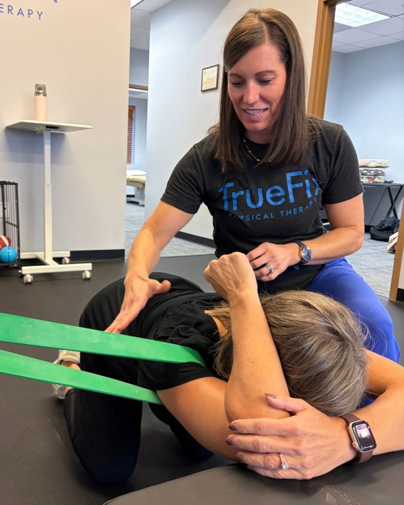 Physical therapist teaches shoulder exercise at TrueFix Physical Therapy in Shawnee, KS
