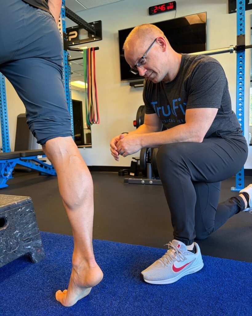 Physical therapist teaches an ankle exercise at TrueFix Physical Therapy in Overland Park, KS.