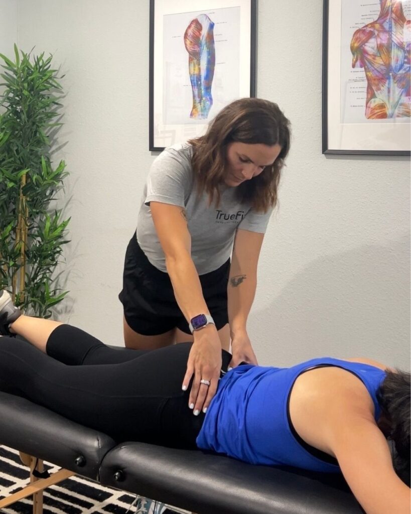 Physical therapist performs a lower back assessment at TrueFix Physical Therapy in Mansfield, TX.