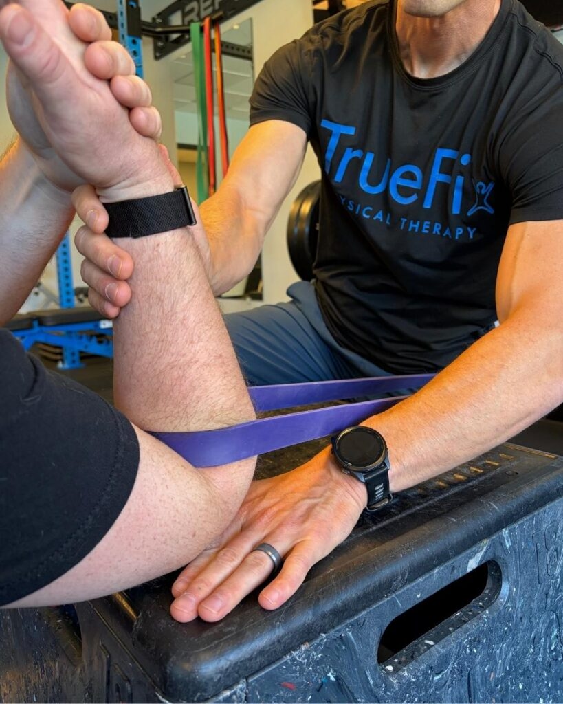 Physical therapist teaches an elbow exercise at TrueFix Physical Therapy in Overland Park, KS.