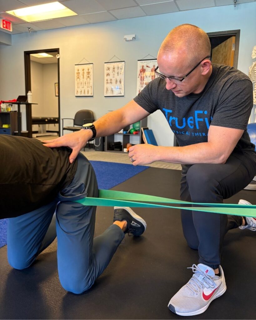 Physical therapist teaches a hip exercise at TrueFix Physical Therapy in Overland Park, KS.