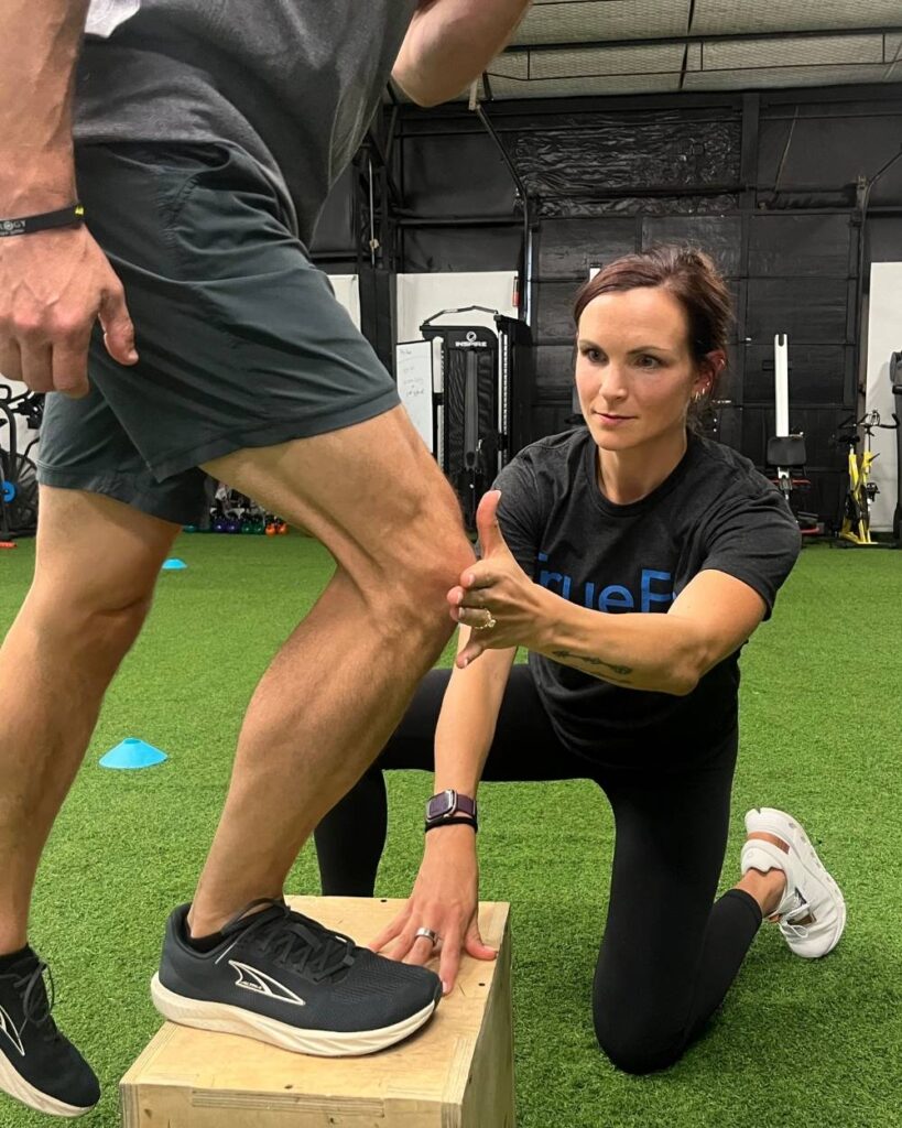 Physical therapist teaches a knee exercise at TrueFix Physical Therapy in Mansfield, TX.