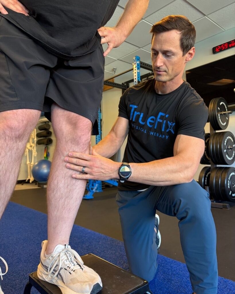 Physical therapist teaches a knee exercise at TrueFix Physical Therapy in Overland Park, KS.
