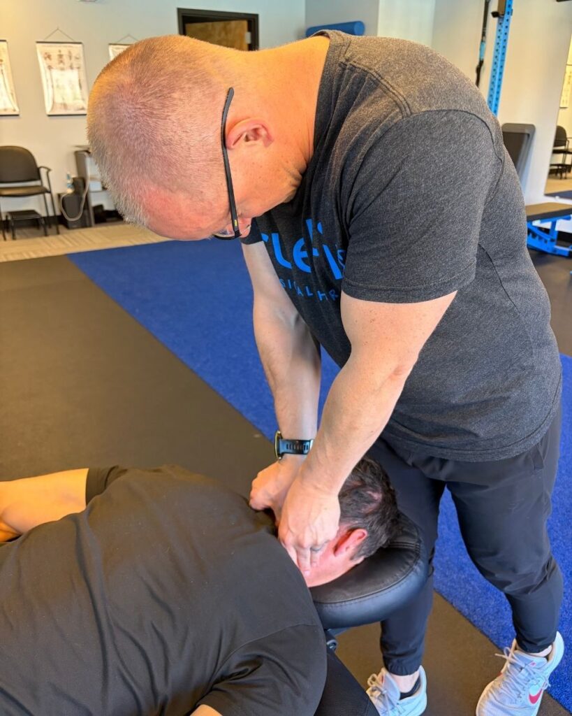 Physical therapist performs a neck mobilization at TrueFix Physical Therapy in Overland Park, KS.