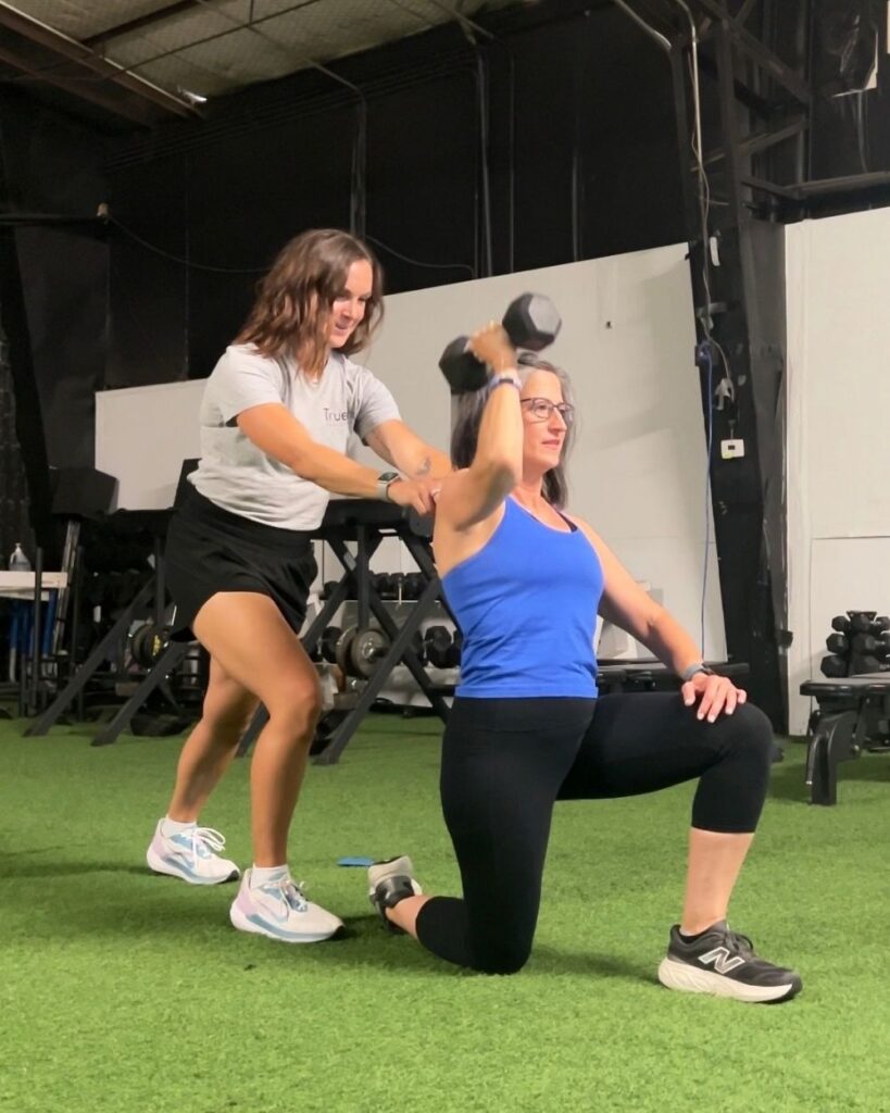 Physical therapist teaches a shoulder exercise at TrueFix Physical Therapy in Mansfield, TX.